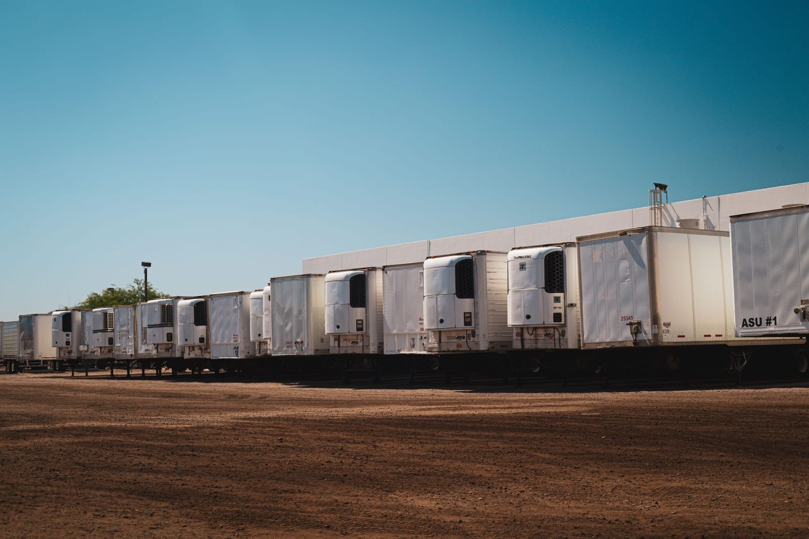 Refrigerated trucks parked in an industrial lot, representing cold chain logistics for temperature-sensitive cargo in Pakistan