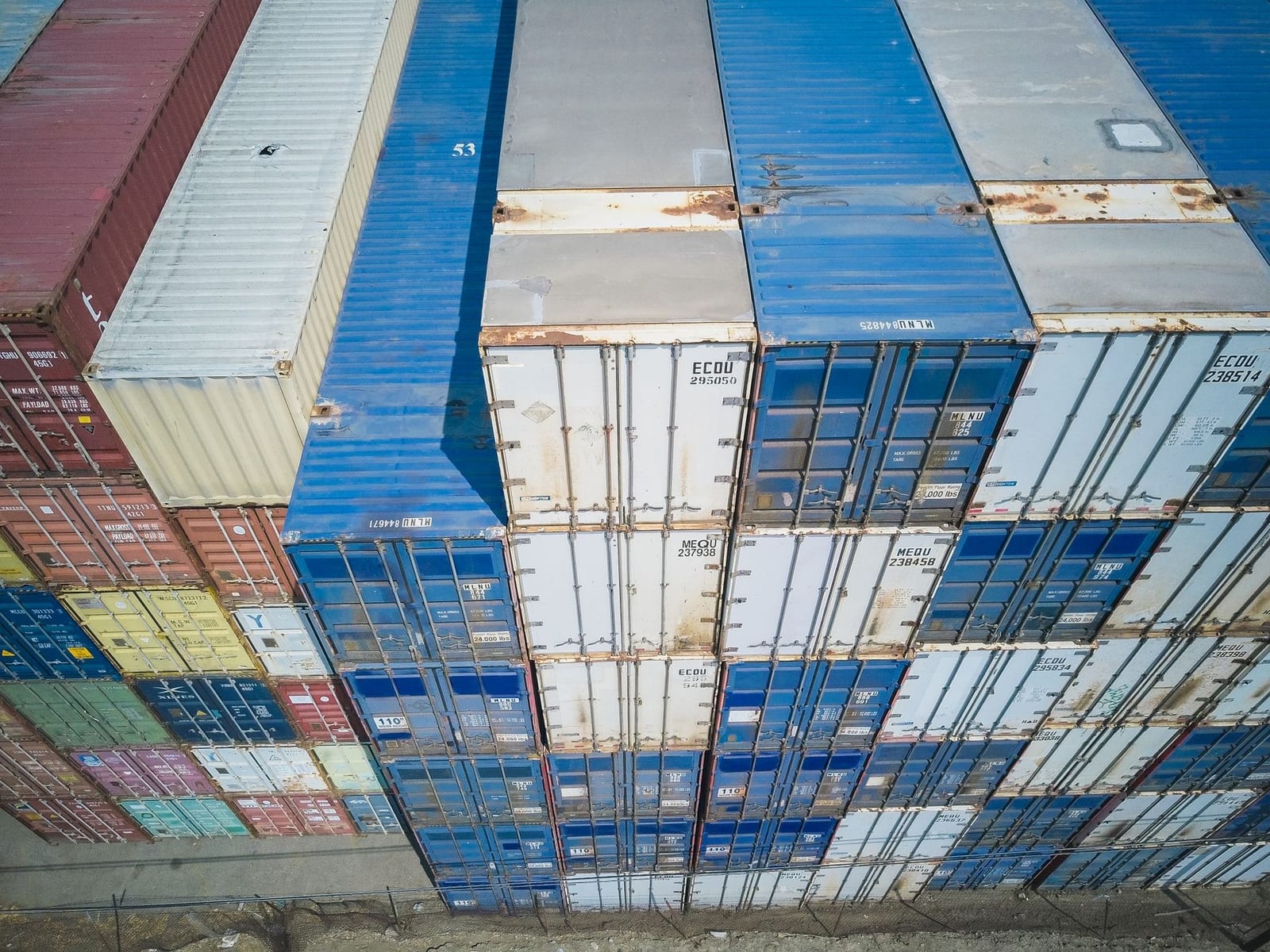 Aerial view of multicoloured shipping containers stacked at a cargo yard, representing full and less than container load sea freight