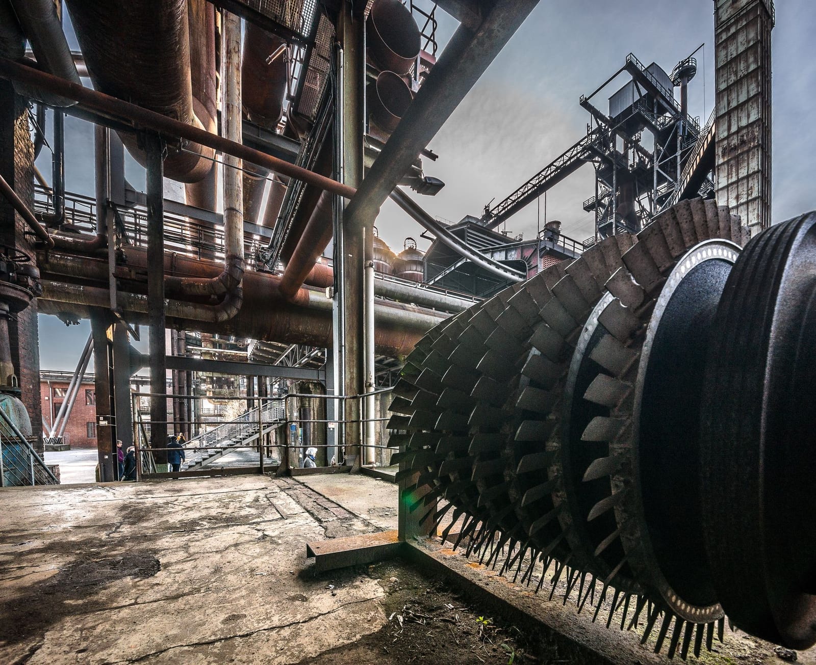 Large industrial turbine machinery and steel piping at a heavy-industry plant, representing machinery imported into Pakistan as project cargo
